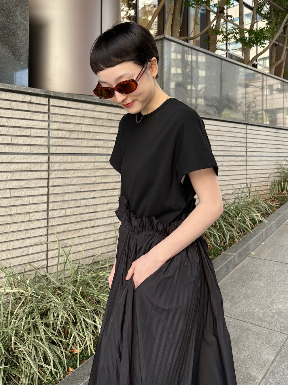 ブラック系のワンピース、ブルー系のショルダーバッグ、ブルー系のスニーカーを着用したレディースの夏コーディネートの5枚目の写真