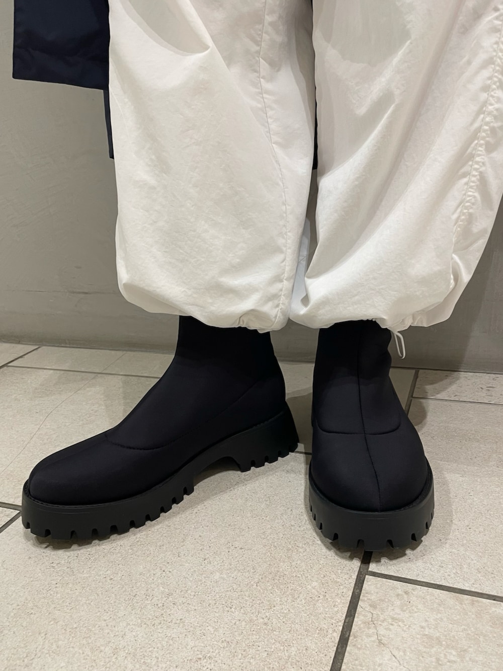 ブラック系のTシャツ/カットソー、ブルー系のナイロンジャケット、ホワイト系のその他パンツを着用したレディースの春コーディネートの5枚目の写真