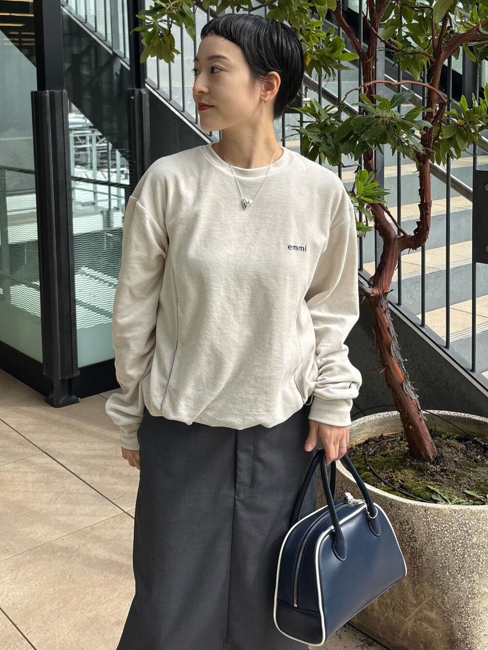 ホワイト系のダウンジャケット/コート、ホワイト系のTシャツ/カットソー、グレー系のスカートを着用したレディースの秋コーディネートの4枚目の写真