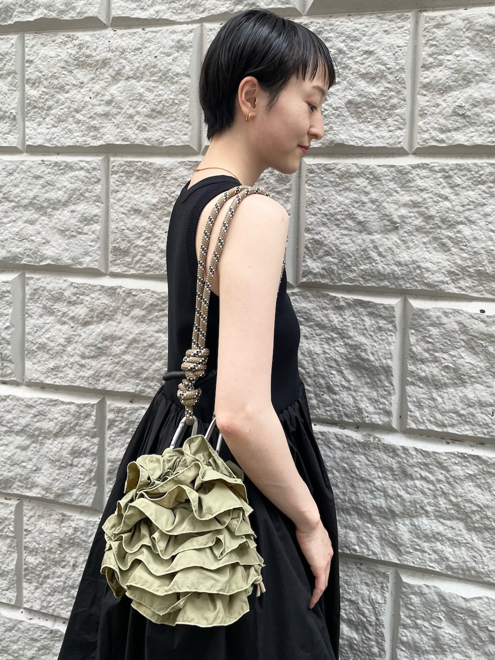 ブラック系のワンピース、グリーン系のショルダーバッグ、ホワイト系のデニムパンツを着用したレディースの夏コーディネートの4枚目の写真