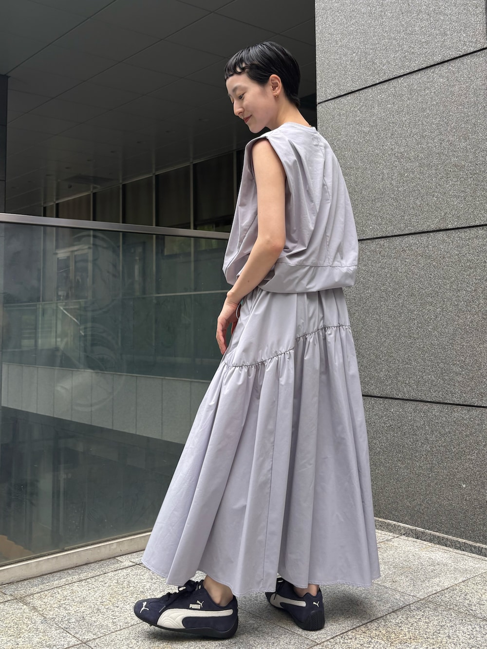 ブルー系のワンピース、ホワイト系のハンドバッグ、ブルー系のスニーカーを着用したレディースの夏コーディネートの4枚目の写真