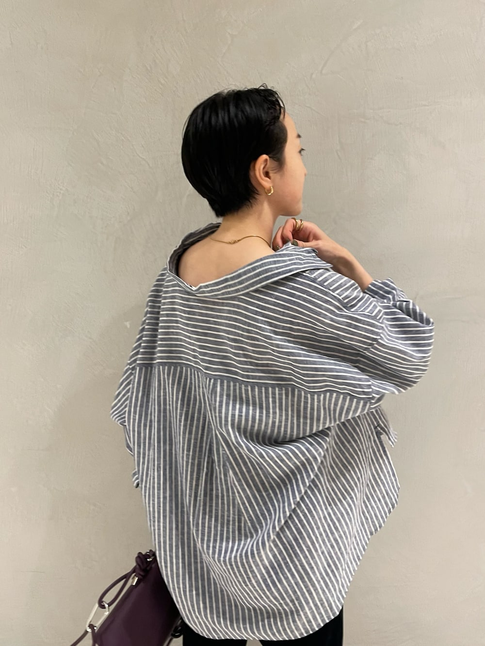 ブルー系のシャツ/ブラウス、ブラック系のパンツ、パープル系のショルダーバッグを着用したレディースの夏コーディネートの4枚目の写真