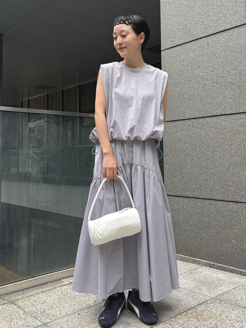 ブルー系のワンピース、ホワイト系のハンドバッグ、ブルー系のスニーカーを着用したレディースの夏コーディネートの2枚目の写真