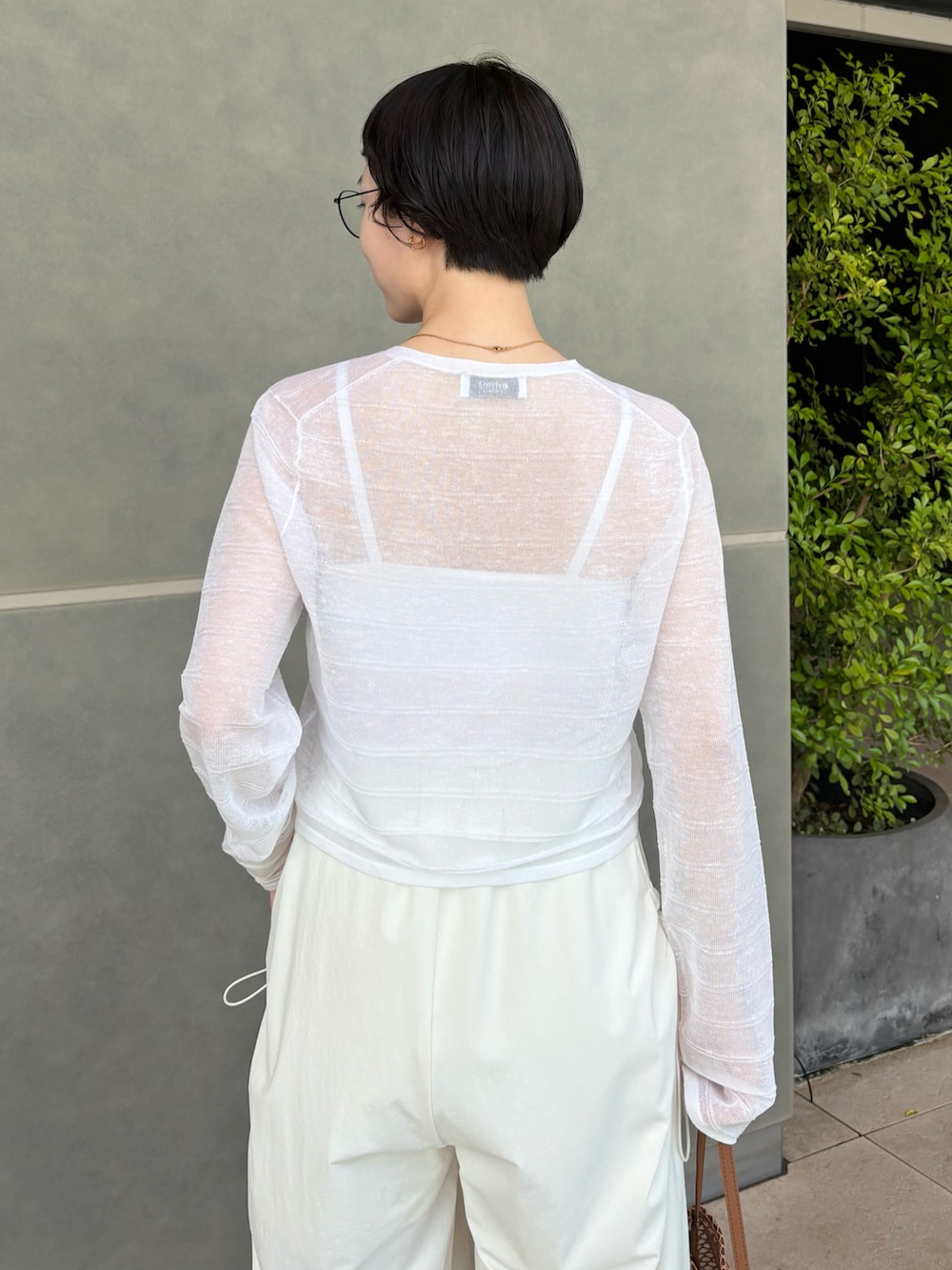 ホワイト系のカーディガン/ボレロ、ホワイト系のその他パンツ、ブラウン系のトートバッグを着用したレディースの春コーディネートの3枚目の写真