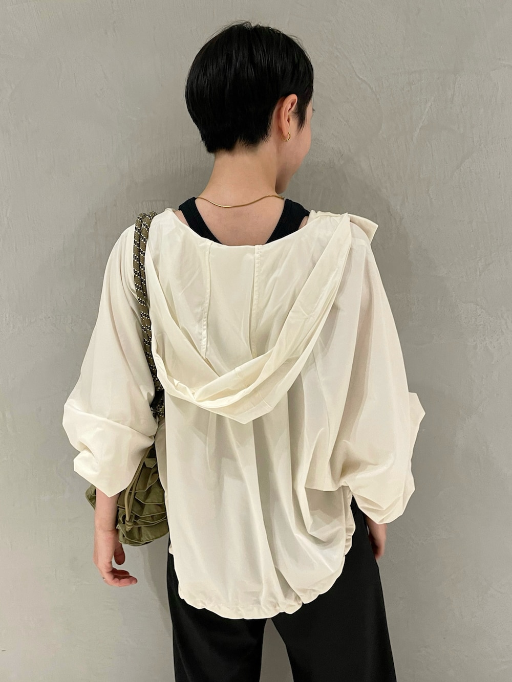 ブラック系のタンクトップ、ホワイト系のナイロンジャケット、ブラック系のスラックスを着用したレディースの夏コーディネートの5枚目の写真