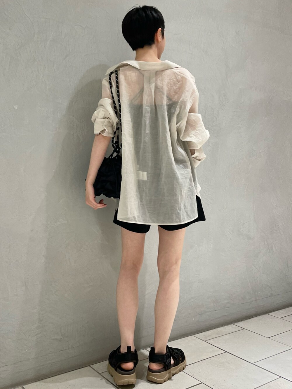 ベージュ系のシャツ/ブラウス、ブラック系のショルダーバッグ、ブラック系のサンダルを着用したレディースの夏コーディネートの2枚目の写真