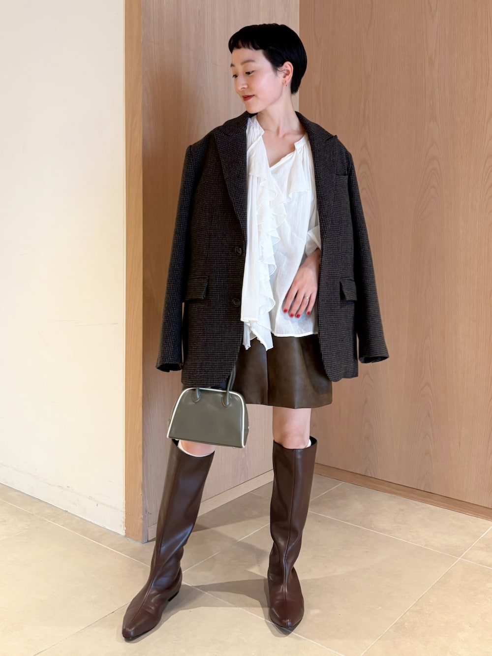 ホワイト系のシャツ/ブラウス、グレー系のテーラードジャケット、ブラウン系のスカートを着用したレディースの秋コーディネートの2枚目の写真
