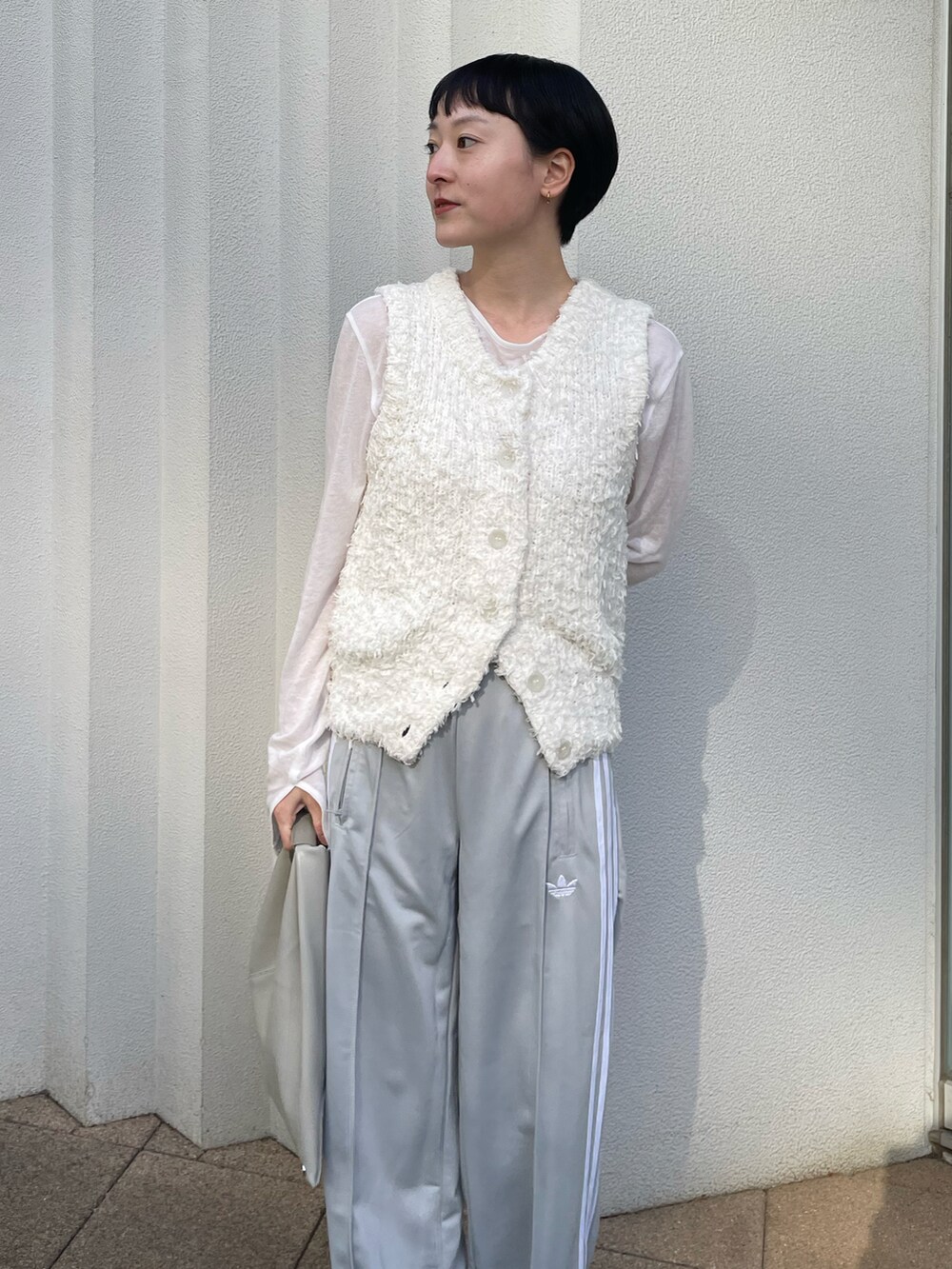 ホワイト系のニット/セーター、ホワイト系のTシャツ/カットソー、グレー系のその他パンツを着用したレディースの春コーディネートの3枚目の写真