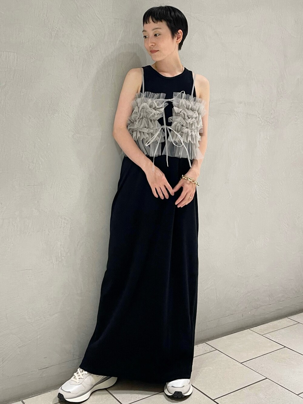 グレー系のキャミソール、ブラック系のワンピース、ブルー系のスニーカーを着用したレディースの夏コーディネートの2枚目の写真