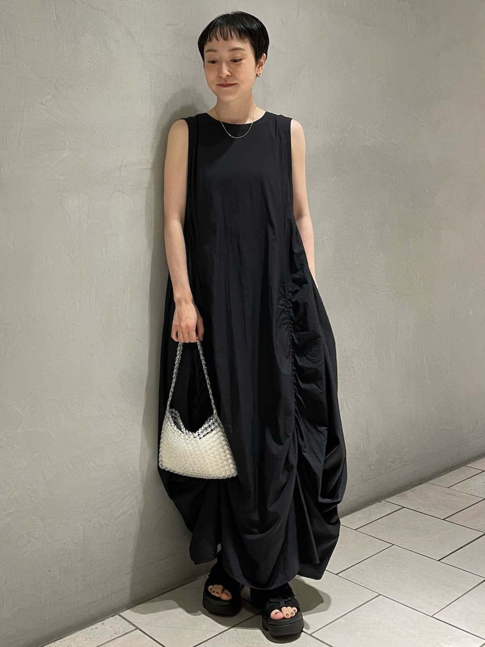 ブラック系のワンピース、その他のハンドバッグ、ブラック系のサンダルを着用したレディースの春コーディネートの3枚目の写真