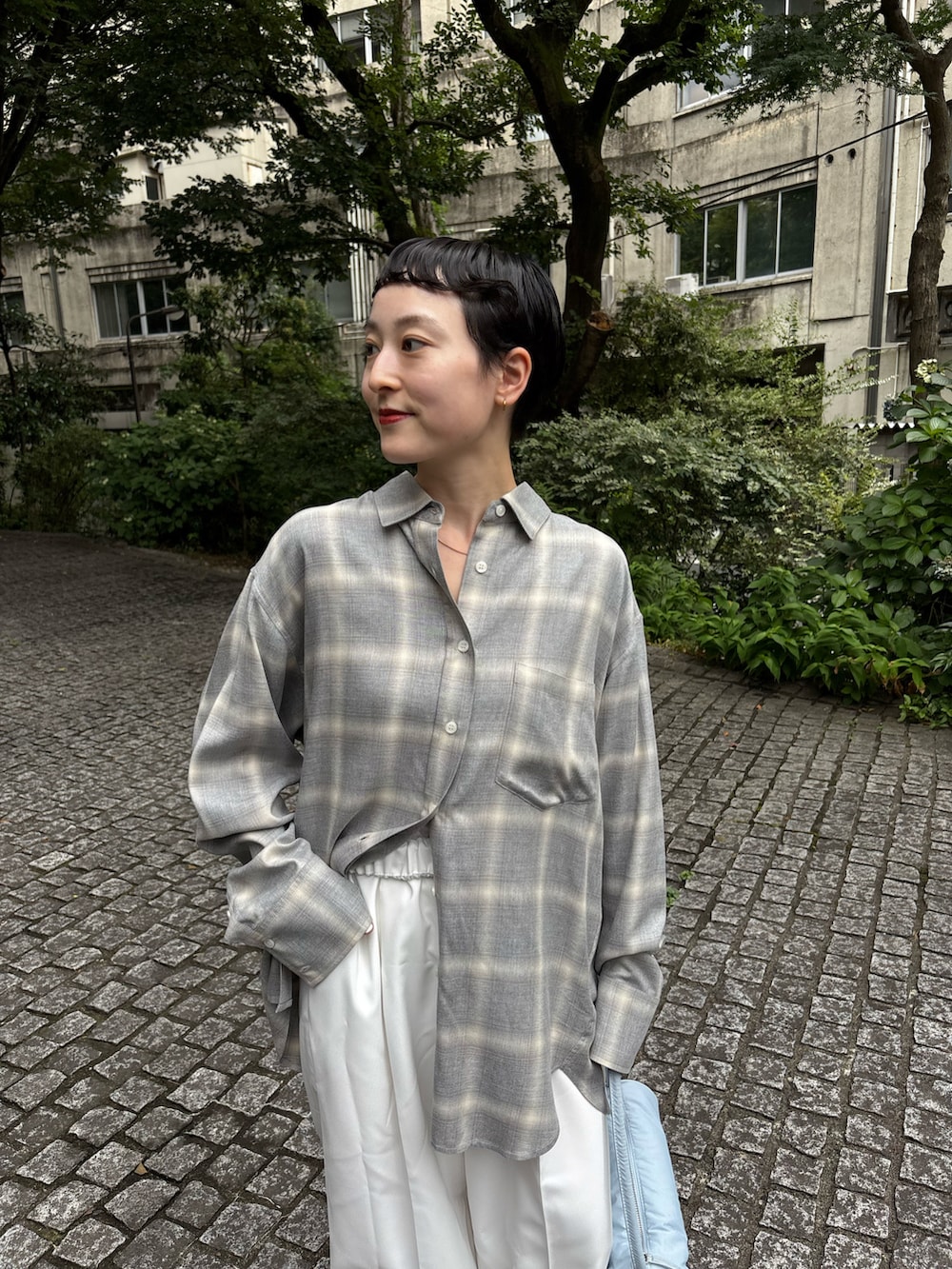 グレー系のシャツ/ブラウス、ホワイト系のその他パンツ、ブルー系のハンドバッグを着用したレディースの夏コーディネートの2枚目の写真