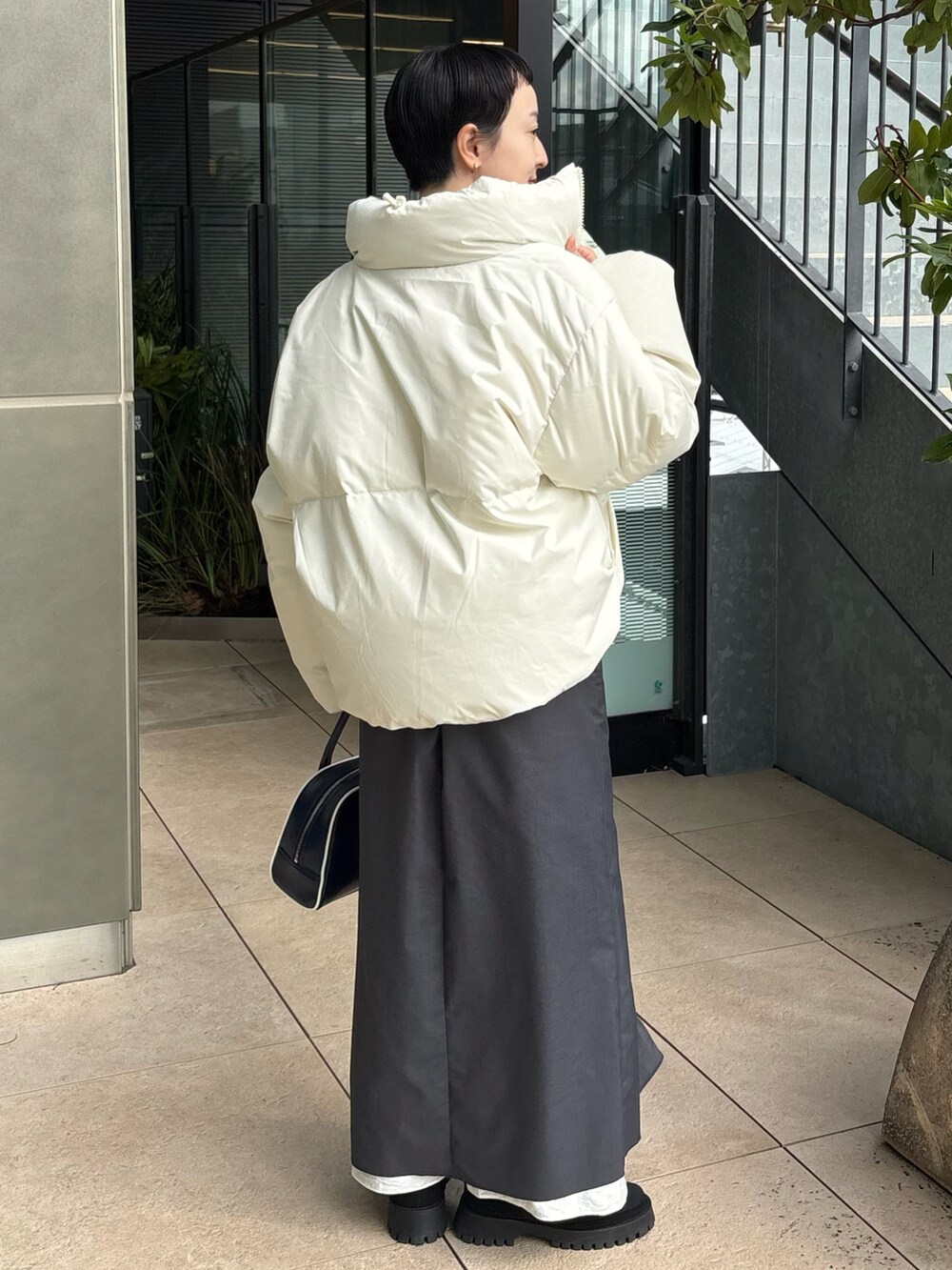 ホワイト系のダウンジャケット/コート、ホワイト系のTシャツ/カットソー、グレー系のスカートを着用したレディースの秋コーディネートの3枚目の写真