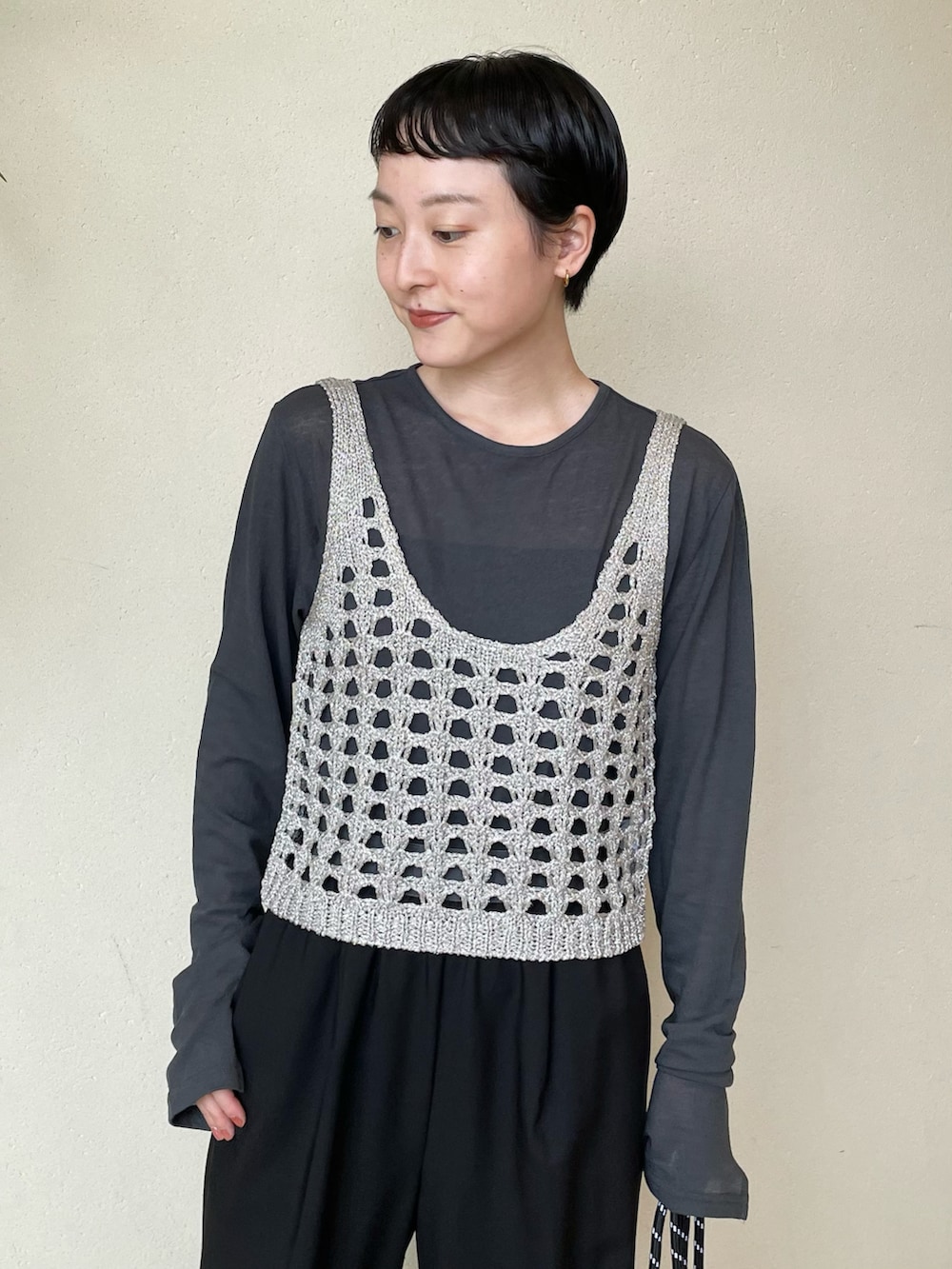 ブラック系のニット/セーター、ブラック系のTシャツ/カットソー、ブラック系のスラックスを着用したレディースの秋コーディネートの2枚目の写真