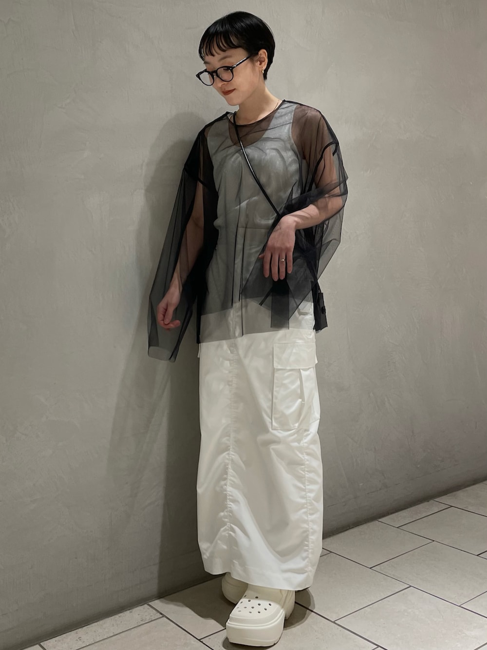 ホワイト系のタンクトップ、ブラック系のTシャツ/カットソー、ホワイト系のスカートを着用したレディースの冬コーディネートの2枚目の写真