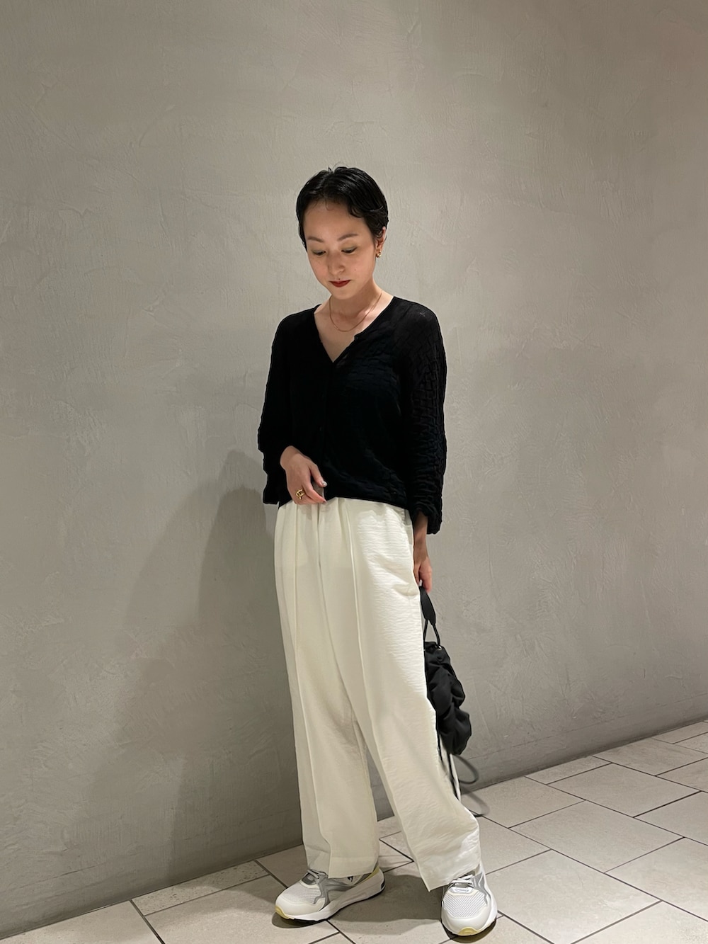 ブラック系のキャミソール、ブラック系のニット/セーター、ホワイト系のその他パンツを着用したレディースの春コーディネートの2枚目の写真