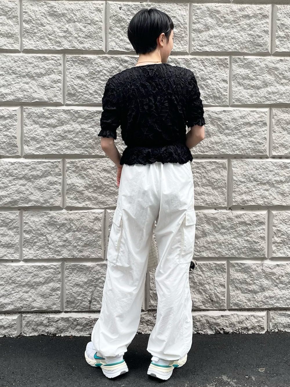 ブラック系のTシャツ/カットソー、ホワイト系のその他パンツ、その他のハンドバッグを着用したレディースの春コーディネートの3枚目の写真
