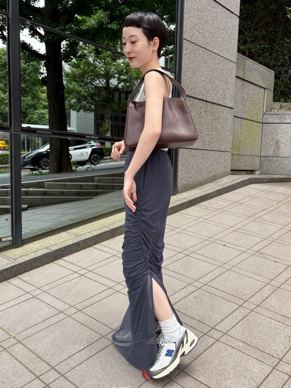 ホワイト系のタンクトップ、ブルー系のスカート、ブラウン系のショルダーバッグを着用したレディースの夏コーディネートの3枚目の写真