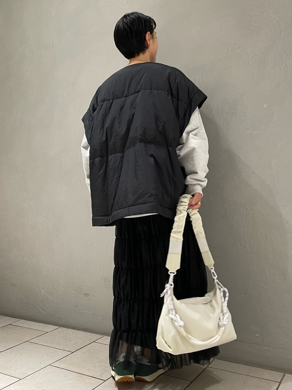 グレー系のスウェット、ブラック系のダウンジャケット/コート、ブラック系のスカートを着用したレディースの冬コーディネートの3枚目の写真