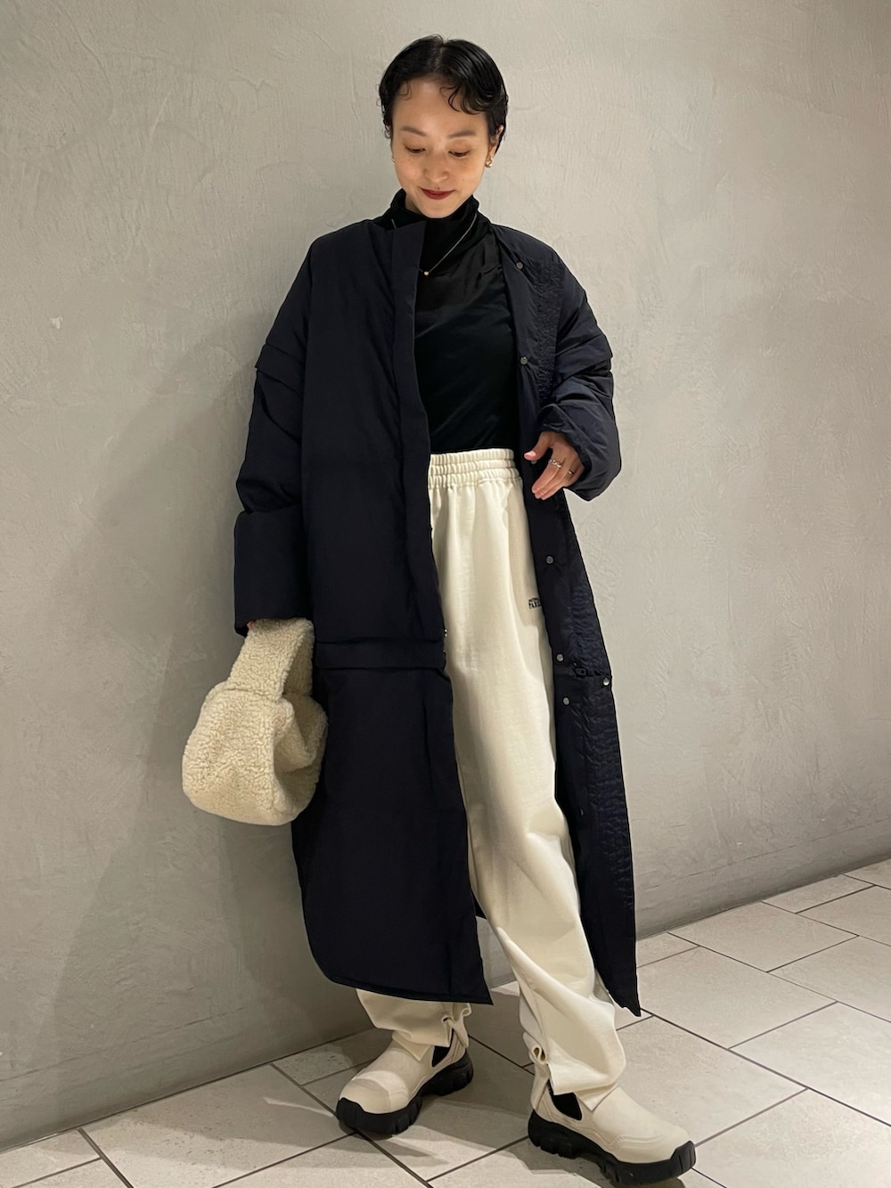 ブラック系のシャツ/ブラウス、ブルー系のダウンジャケット/コート、ホワイト系のスウェットパンツを着用したレディースの秋コーディネートの2枚目の写真