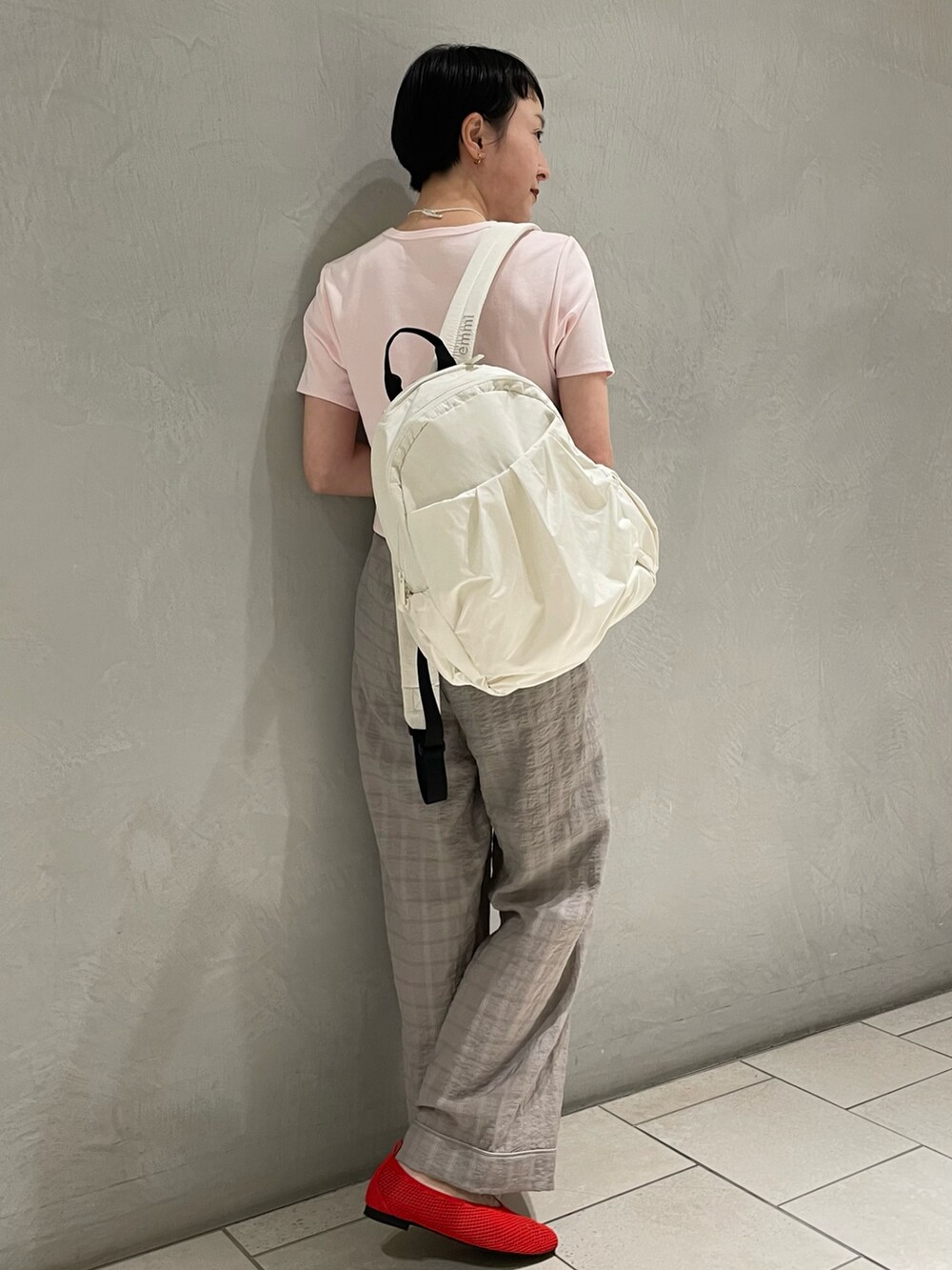 ピンク系のTシャツ/カットソー、グレー系のその他パンツ、ホワイト系のバックパック/リュックを着用したレディースの春コーディネートの3枚目の写真