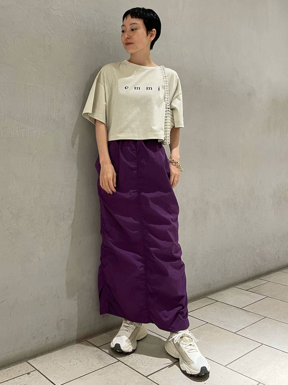 グリーン系のTシャツ/カットソー、パープル系のスカート、その他のハンドバッグを着用したレディースの夏コーディネートの2枚目の写真