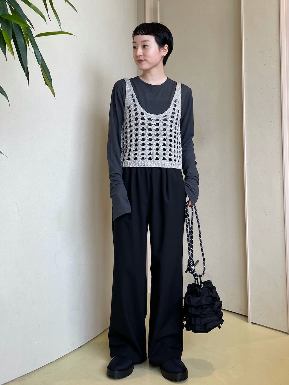 ブラック系のニット/セーター、ブラック系のTシャツ/カットソー、ブラック系のスラックスを着用したレディースの秋コーディネートの5枚目の写真