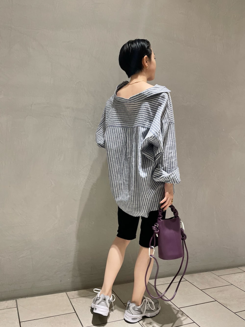 ブルー系のシャツ/ブラウス、ブラック系のパンツ、パープル系のショルダーバッグを着用したレディースの夏コーディネートの3枚目の写真