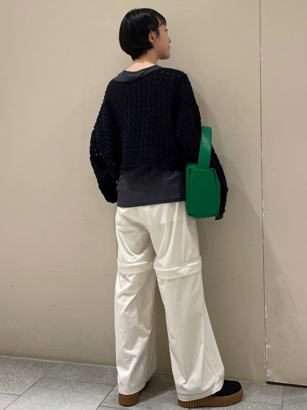 ホワイト系のカーゴパンツ、グレー系のTシャツ/カットソー、ブラック系のニット/セーターを着用したレディースの春コーディネートの3枚目の写真