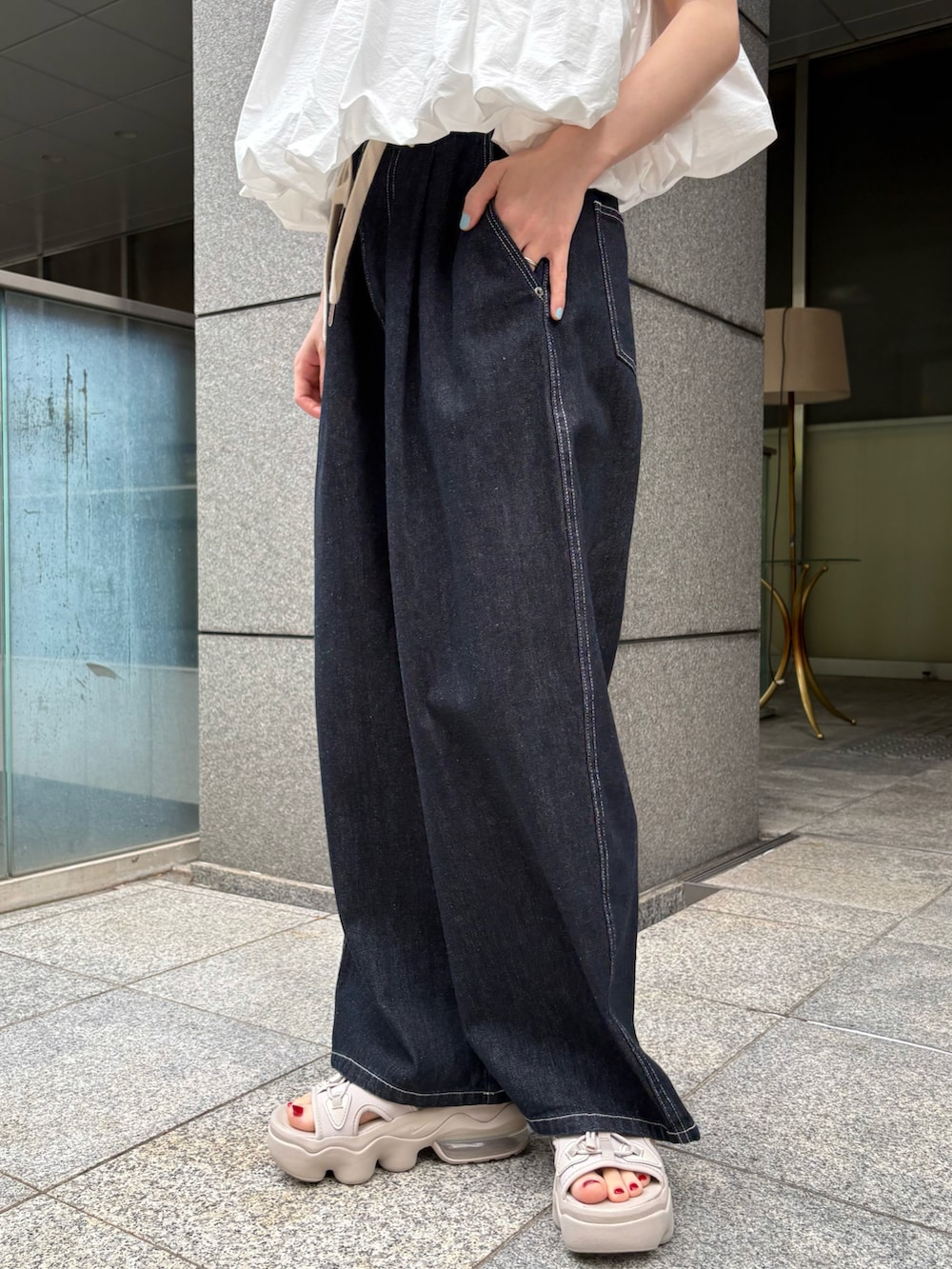 ホワイト系のシャツ/ブラウス、ブルー系のその他パンツ、オレンジ系のバックパック/リュックを着用したレディースの夏コーディネートの3枚目の写真