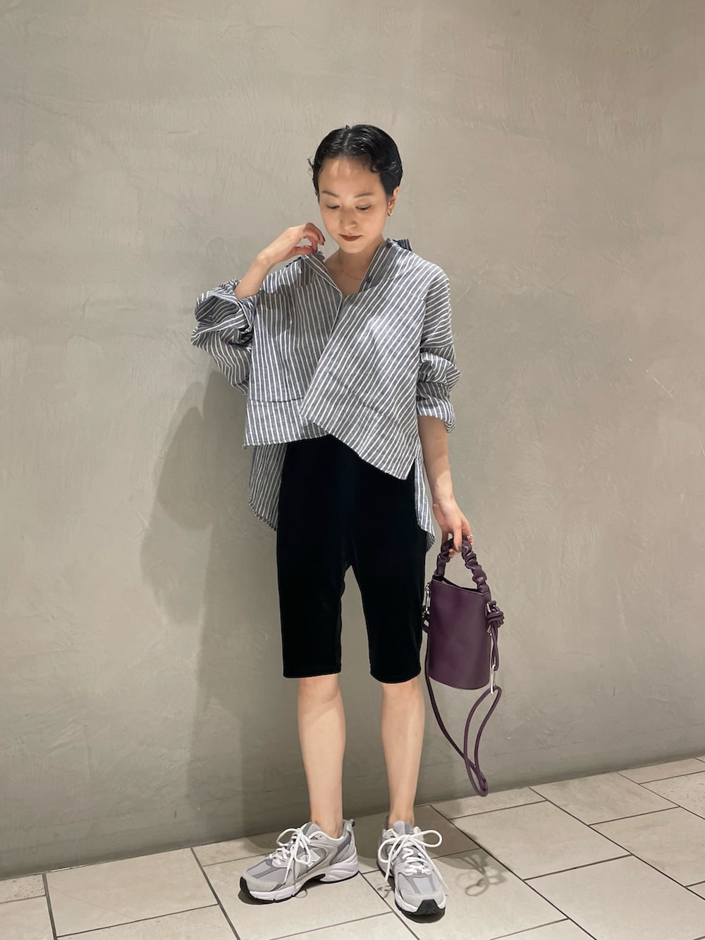 ブルー系のシャツ/ブラウス、ブラック系のパンツ、パープル系のショルダーバッグを着用したレディースの夏コーディネートの2枚目の写真