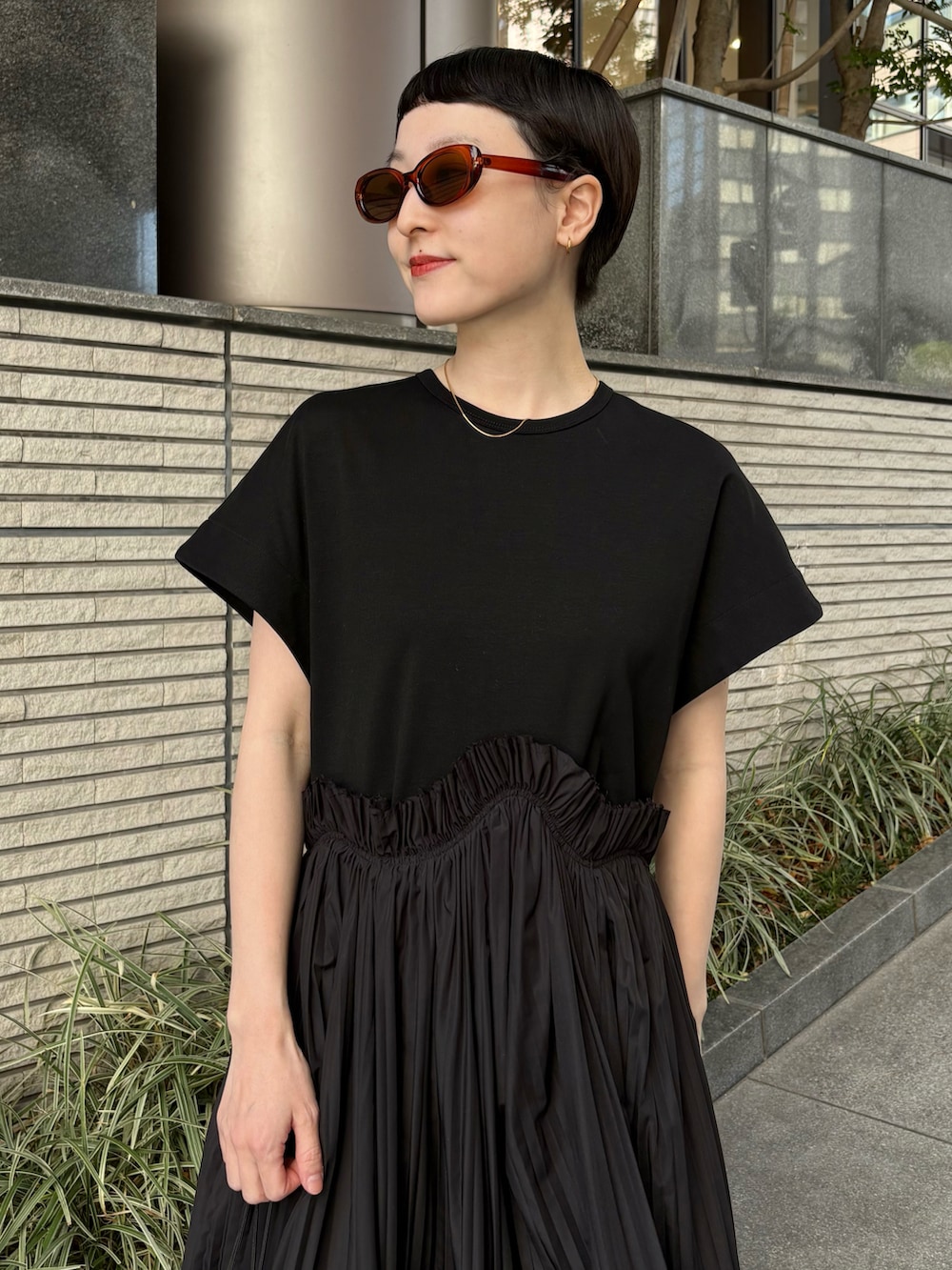 ブラック系のワンピース、ブルー系のショルダーバッグ、ブルー系のスニーカーを着用したレディースの夏コーディネートの3枚目の写真