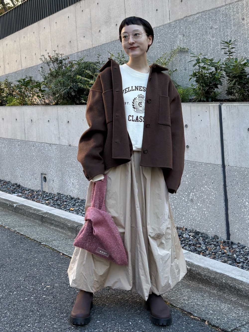 ブラウン系のチェスターコート、ホワイト系のスウェット、ベージュ系のスカートを着用したレディースの冬コーディネートの5枚目の写真
