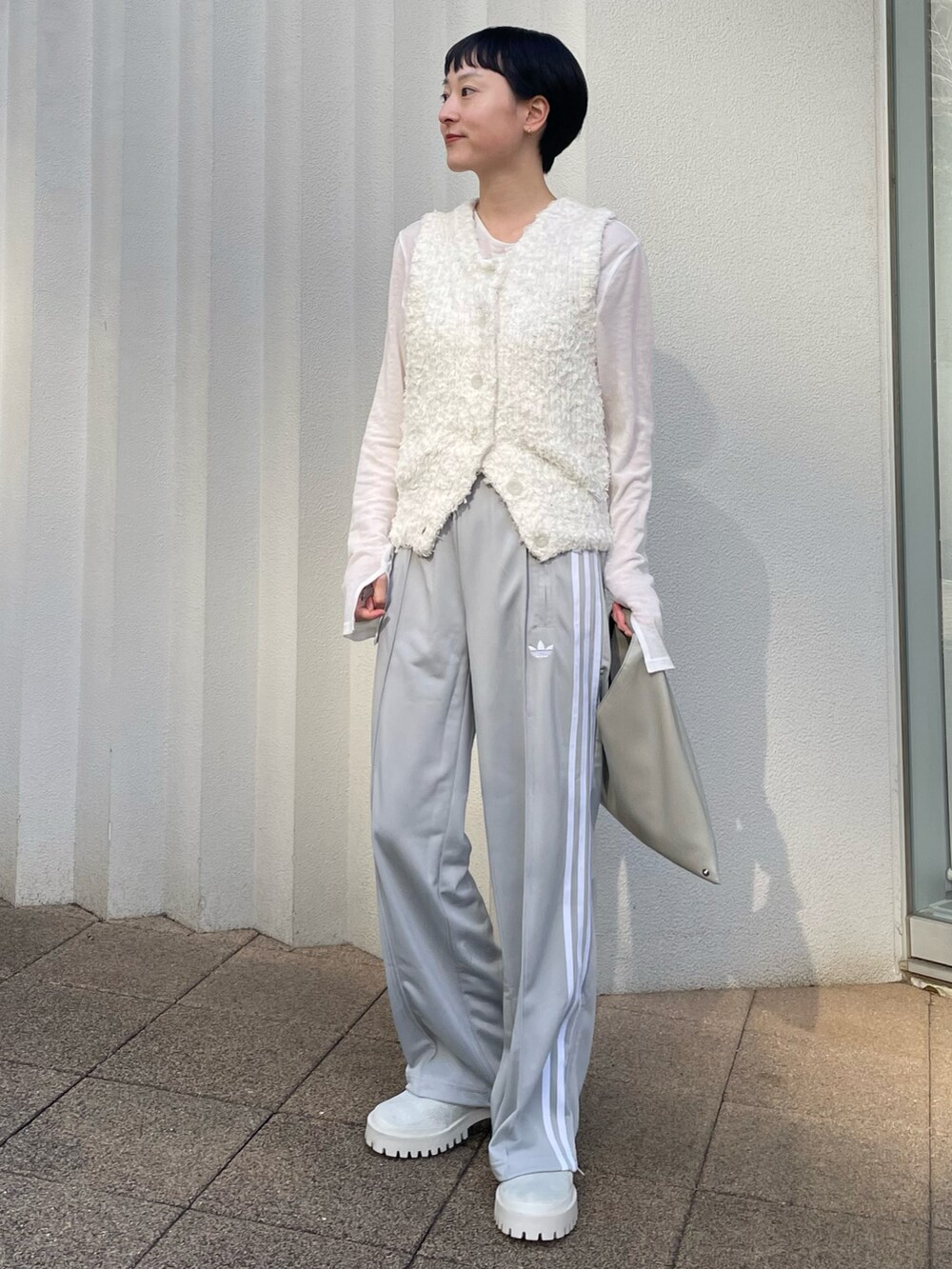 ホワイト系のニット/セーター、ホワイト系のTシャツ/カットソー、グレー系のその他パンツを着用したレディースの春コーディネートの2枚目の写真