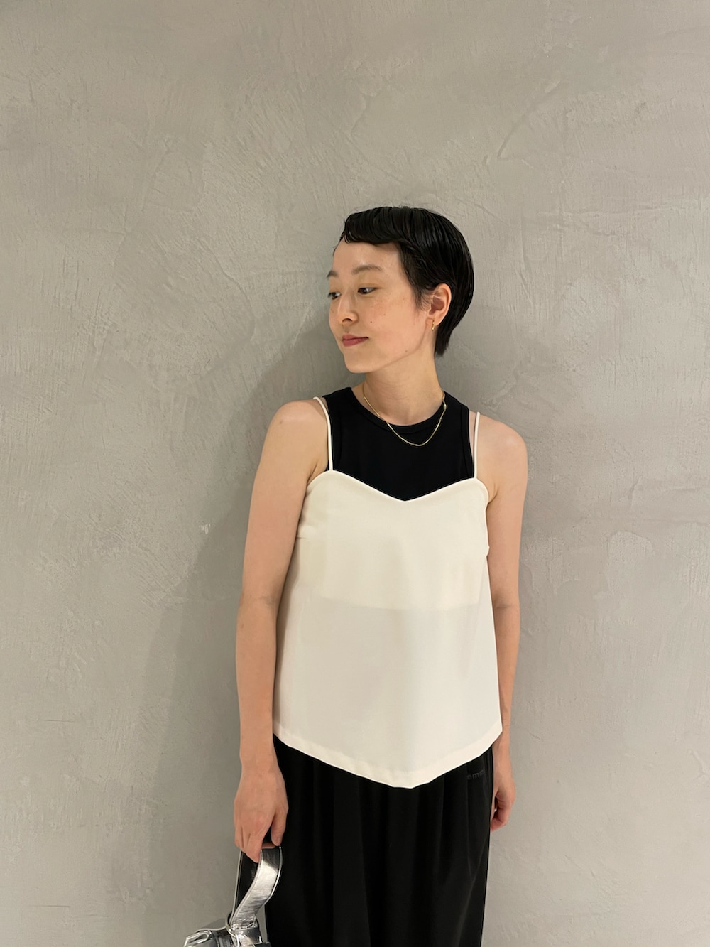 ホワイト系のキャミソール、ブラック系のタンクトップ、ブラック系のその他パンツを着用したレディースの秋コーディネートの2枚目の写真