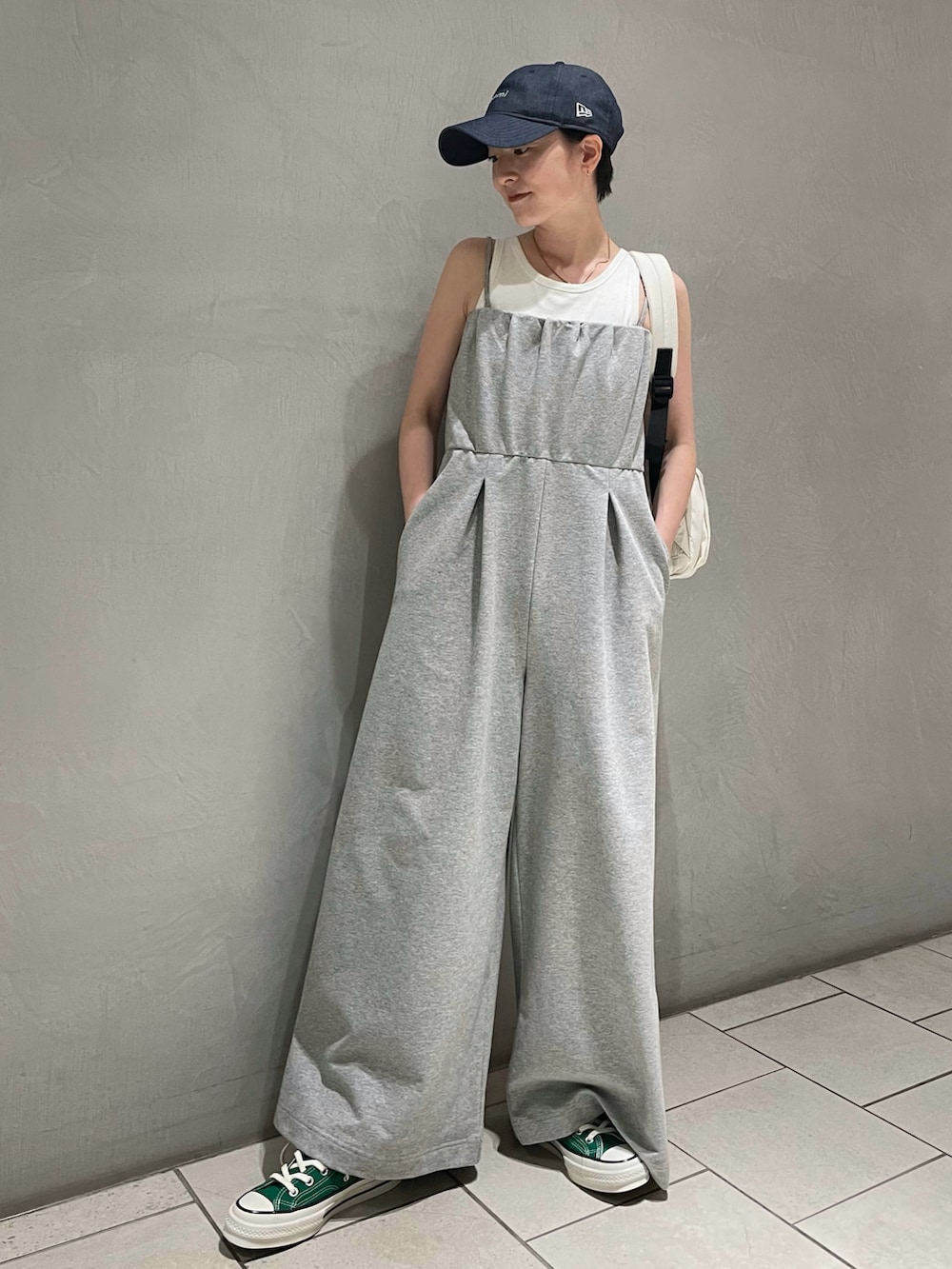 ホワイト系のTシャツ/カットソー、グレー系のつなぎ/オールインワン、ホワイト系のバックパック/リュックを着用したレディースの春コーディネートの2枚目の写真