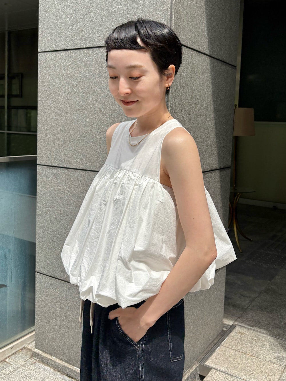 ホワイト系のシャツ/ブラウス、ブルー系のその他パンツ、オレンジ系のバックパック/リュックを着用したレディースの夏コーディネートの2枚目の写真