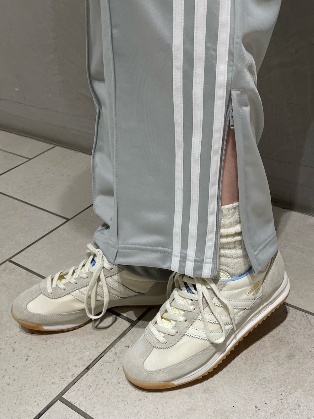 ホワイト系のニット/セーター、ホワイト系のスニーカー、ホワイト系のハンドバッグを着用したレディースの春コーディネートの5枚目の写真