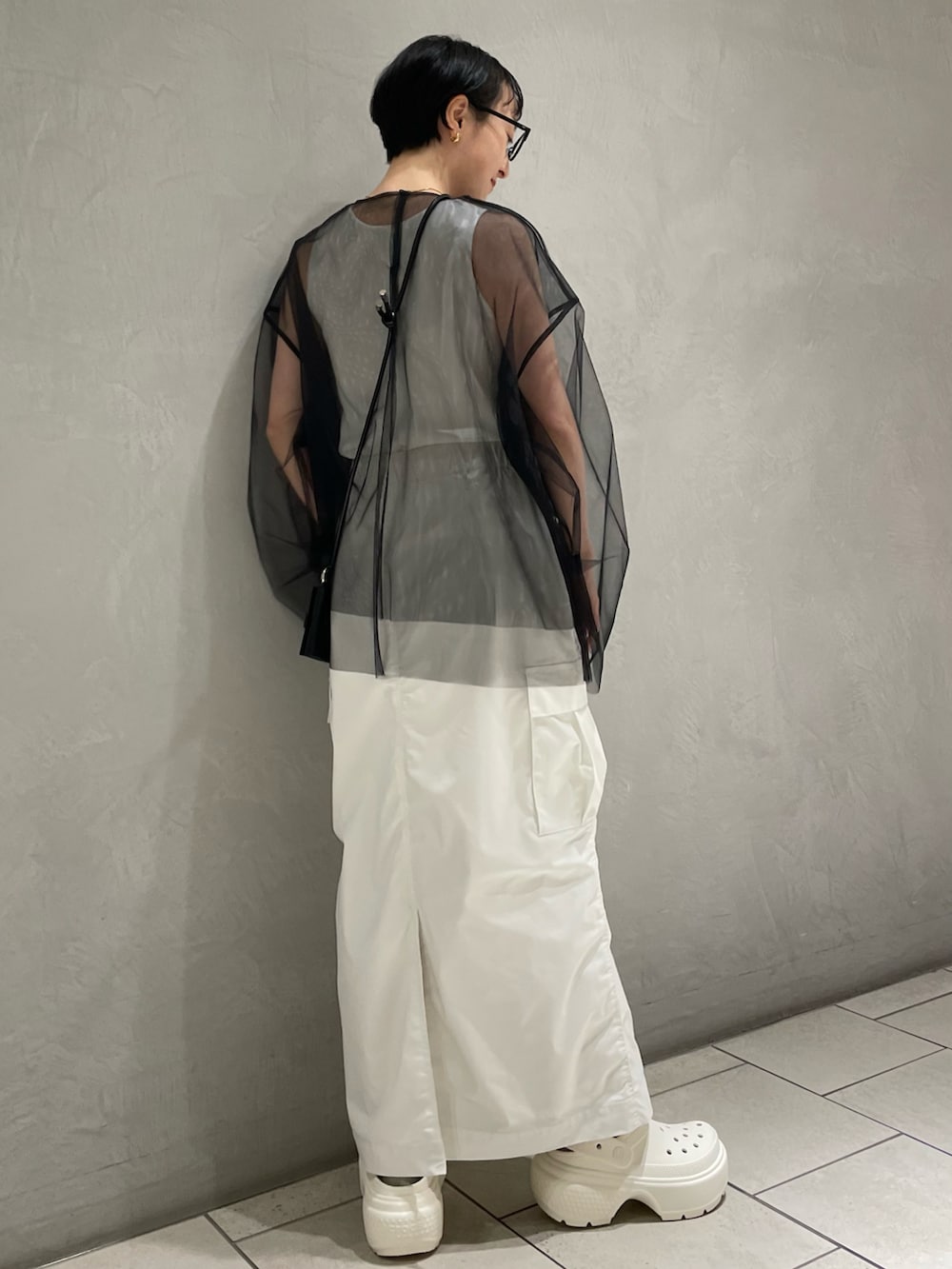 ホワイト系のタンクトップ、ブラック系のTシャツ/カットソー、ホワイト系のスカートを着用したレディースの冬コーディネートの4枚目の写真