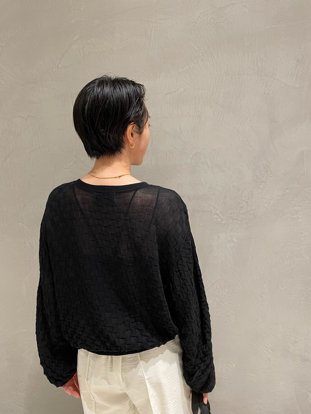 ブラック系のキャミソール、ブラック系のニット/セーター、ホワイト系のその他パンツを着用したレディースの春コーディネートの5枚目の写真