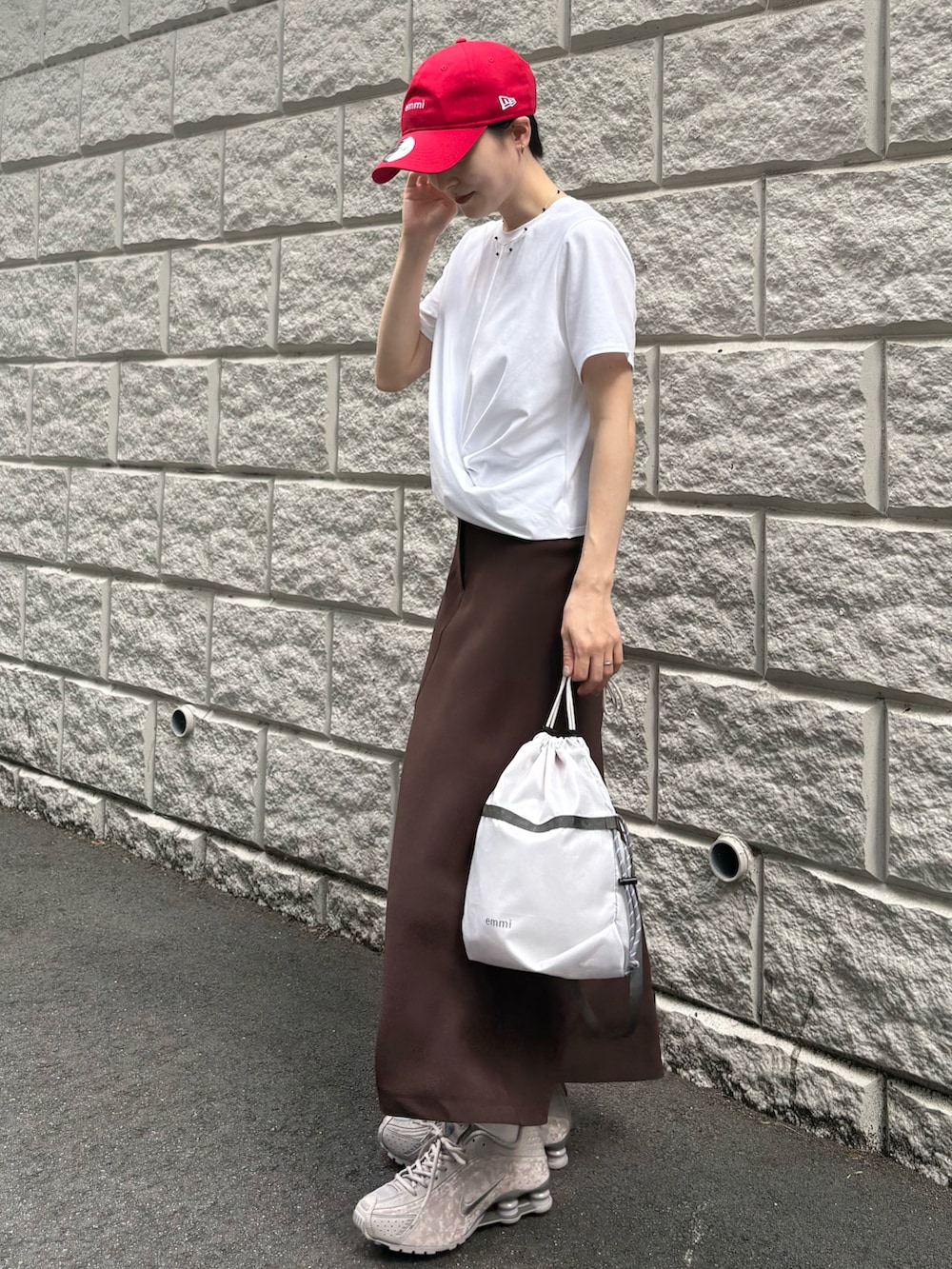 ホワイト系のTシャツ/カットソー、ブラウン系のスカート、グレー系のショルダーバッグを着用したレディースの夏コーディネートの2枚目の写真