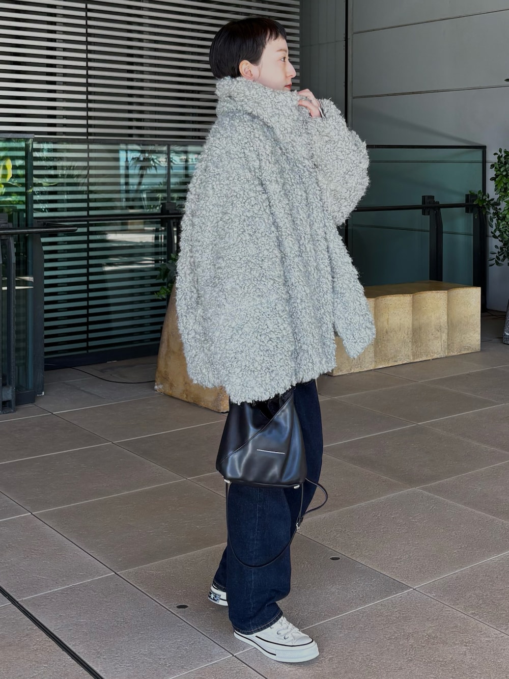 ホワイト系のスニーカー、ブルー系のカーディガン/ボレロ、グリーン系のピーコートを着用したレディースの冬コーディネートの2枚目の写真