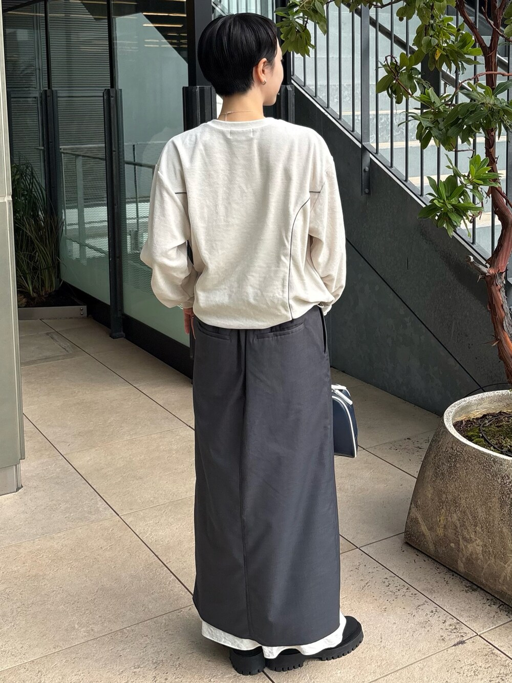 ホワイト系のダウンジャケット/コート、ホワイト系のTシャツ/カットソー、グレー系のスカートを着用したレディースの秋コーディネートの5枚目の写真