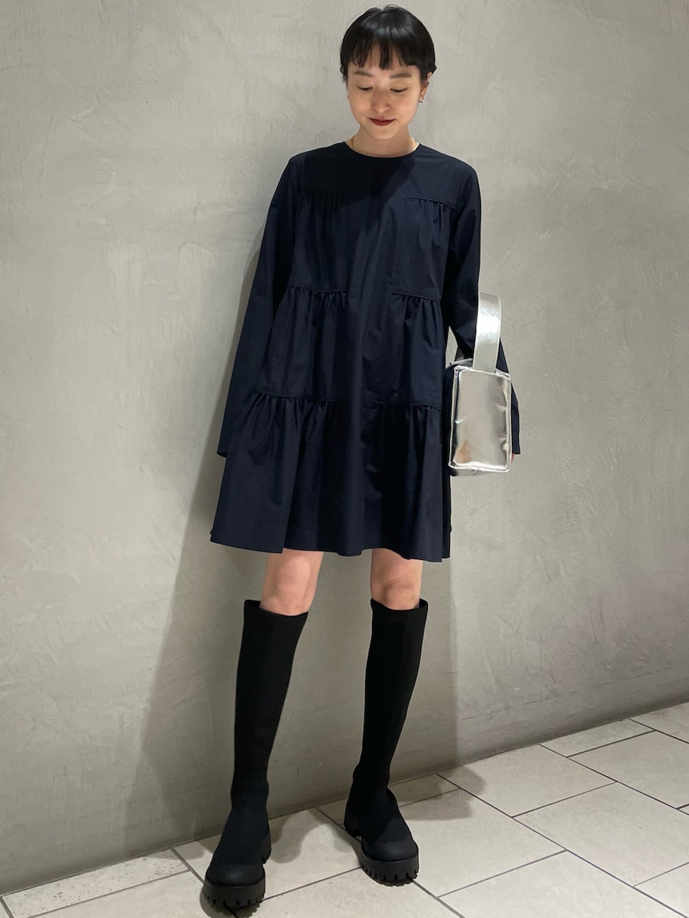 ブルー系のシャツ/ブラウス、ブラック系のブーツ、シルバー系のハンドバッグを着用したレディースの春コーディネートの2枚目の写真