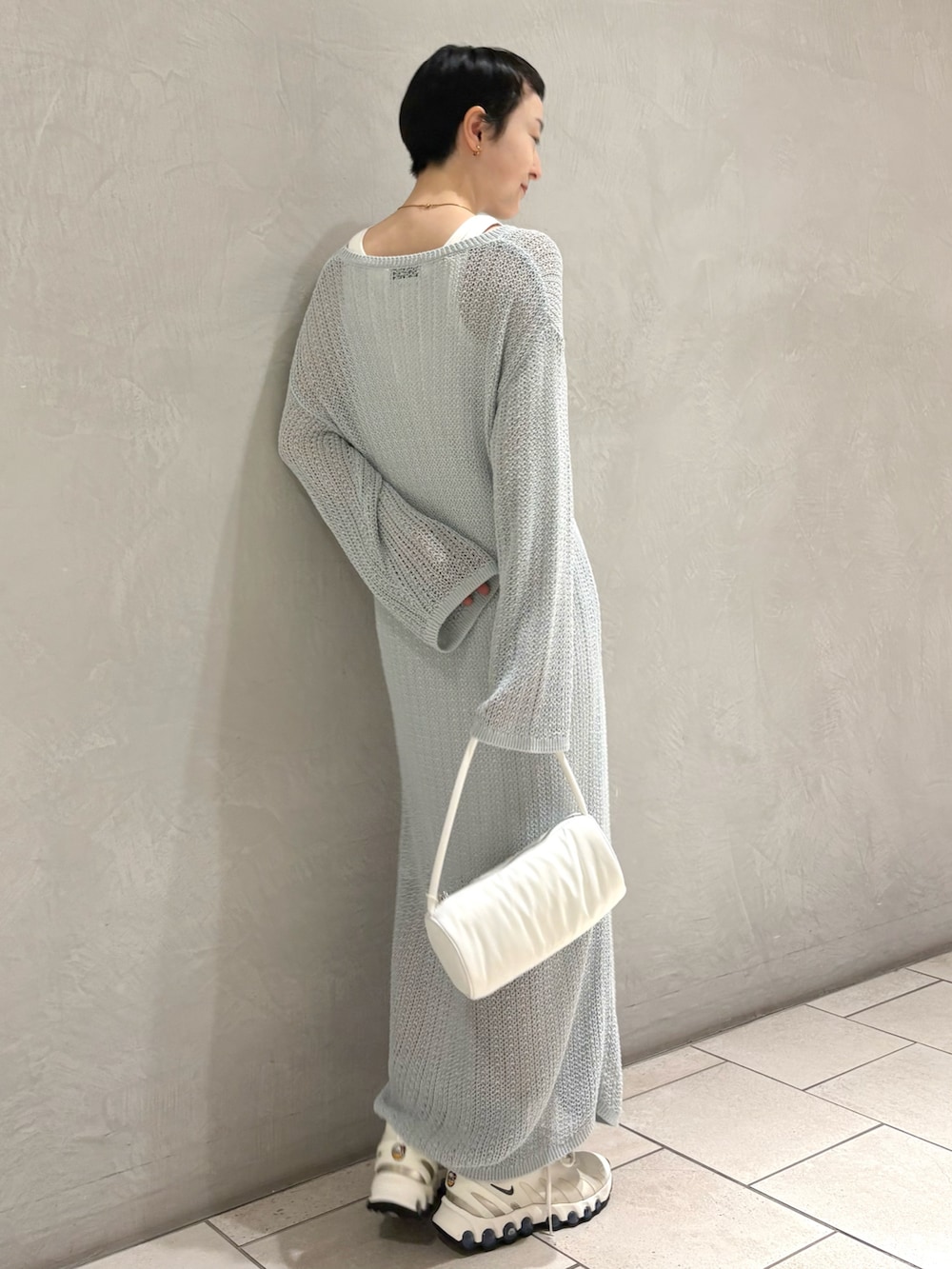 ブルー系のワンピース、ホワイト系のハンドバッグを着用したレディースの夏コーディネートの2枚目の写真