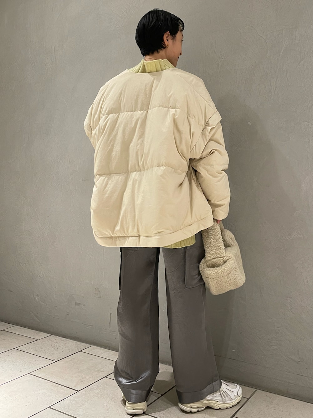 ベージュ系のダウンジャケット/コート、グリーン系のニット/セーター、グリーン系のカーゴパンツを着用したレディースの秋コーディネートの3枚目の写真