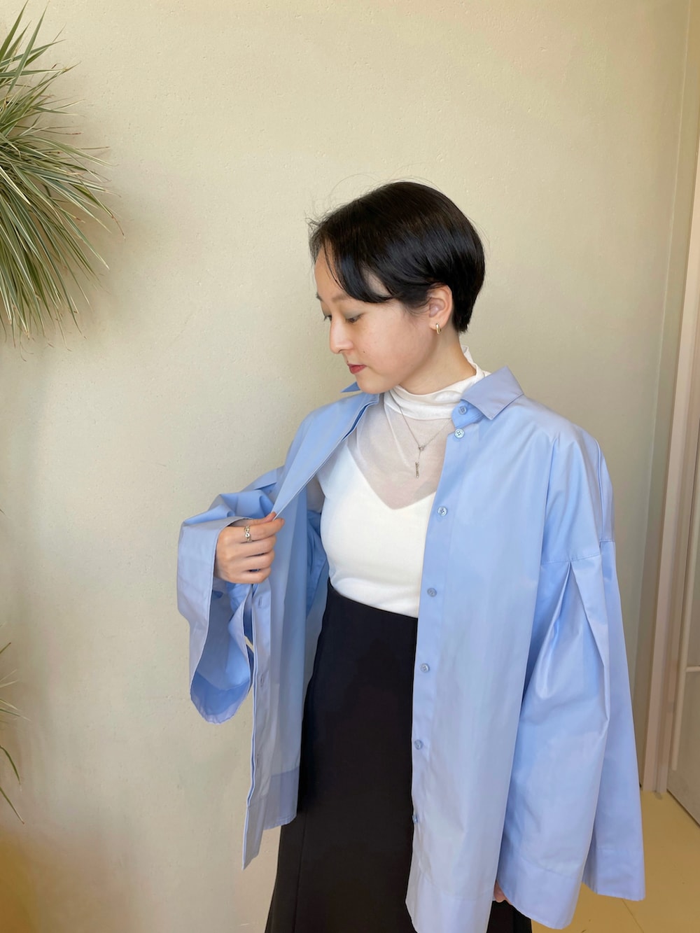 ブルー系のシャツ/ブラウス、ホワイト系のニット/セーター、ホワイト系のキャミソールを着用したレディースの春コーディネートの3枚目の写真