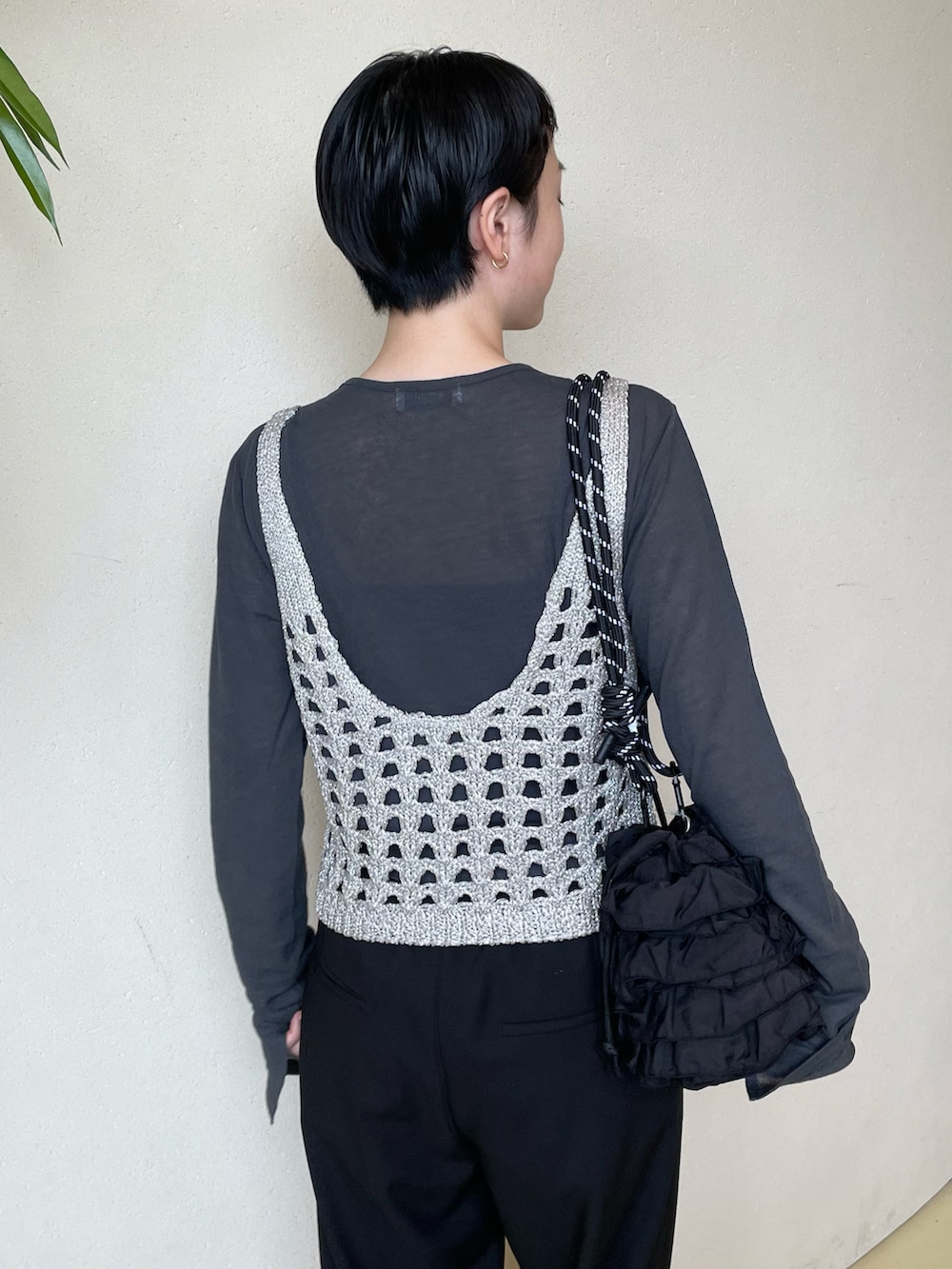 ブラック系のニット/セーター、ブラック系のTシャツ/カットソー、ブラック系のスラックスを着用したレディースの秋コーディネートの3枚目の写真