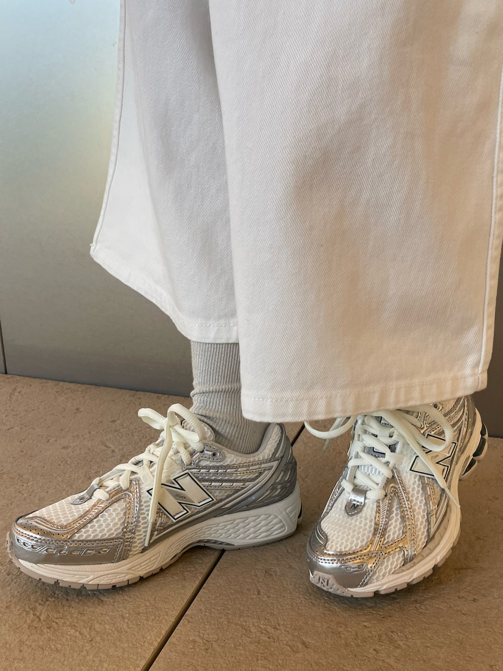 ホワイト系のその他アウター、ホワイト系のデニムパンツ、シルバー系のスニーカーを着用したレディースの冬コーディネートの5枚目の写真