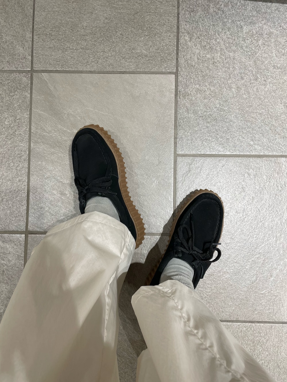 ホワイト系のカーゴパンツ、グレー系のTシャツ/カットソー、ブラック系のニット/セーターを着用したレディースの春コーディネートの4枚目の写真