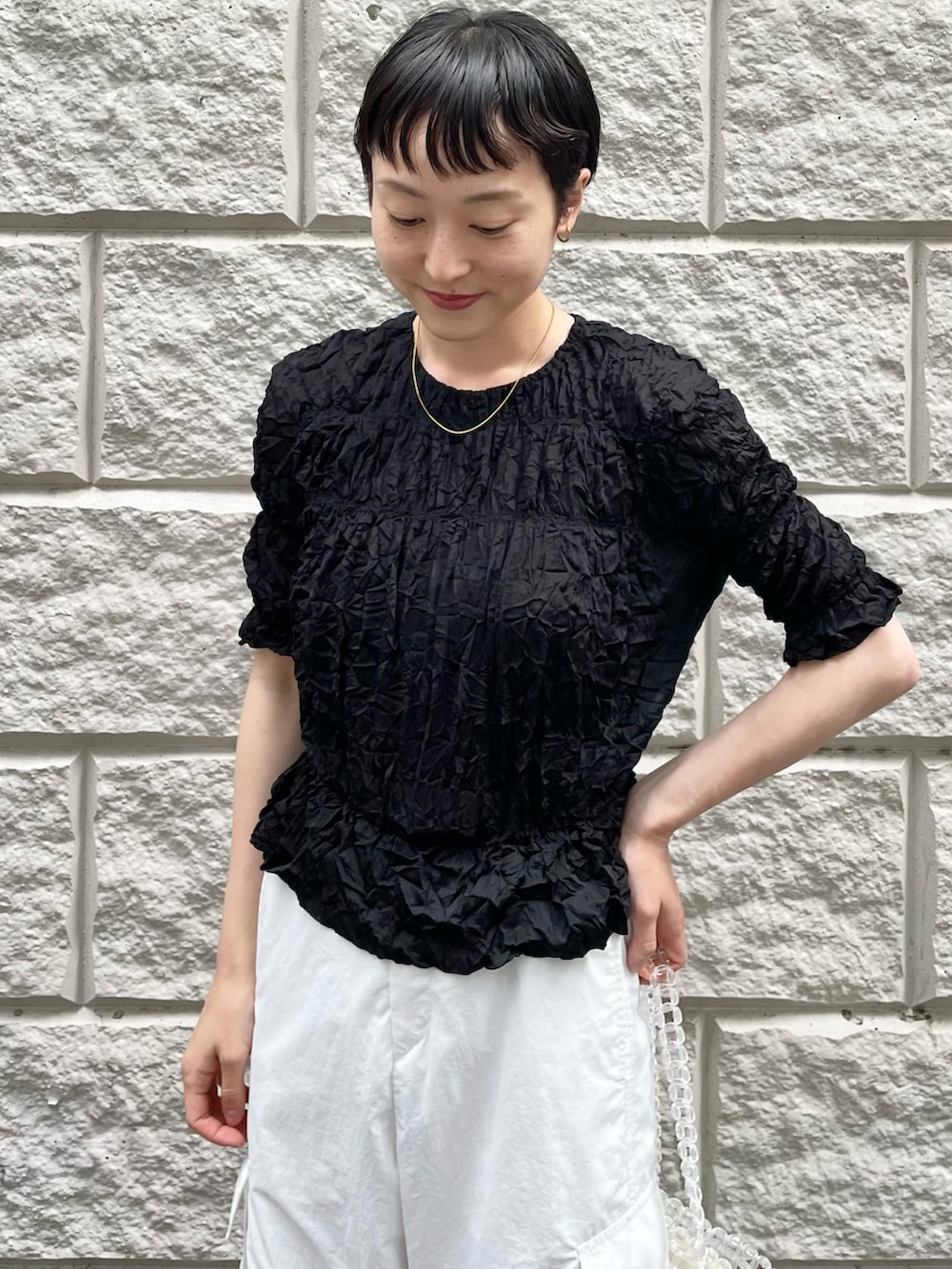 ブラック系のTシャツ/カットソー、ホワイト系のその他パンツ、その他のハンドバッグを着用したレディースの春コーディネートの4枚目の写真